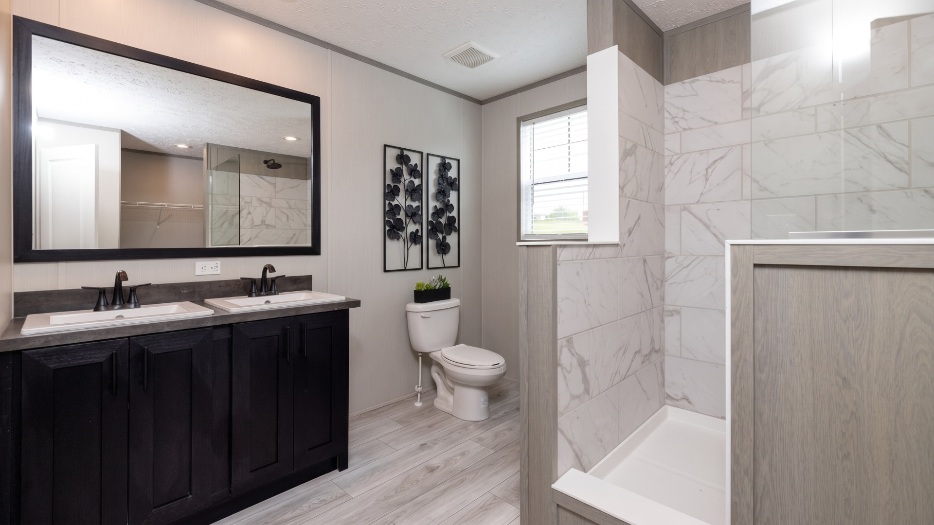 Baño principal con doble lavamanos de la casa móvil Renata 16x76