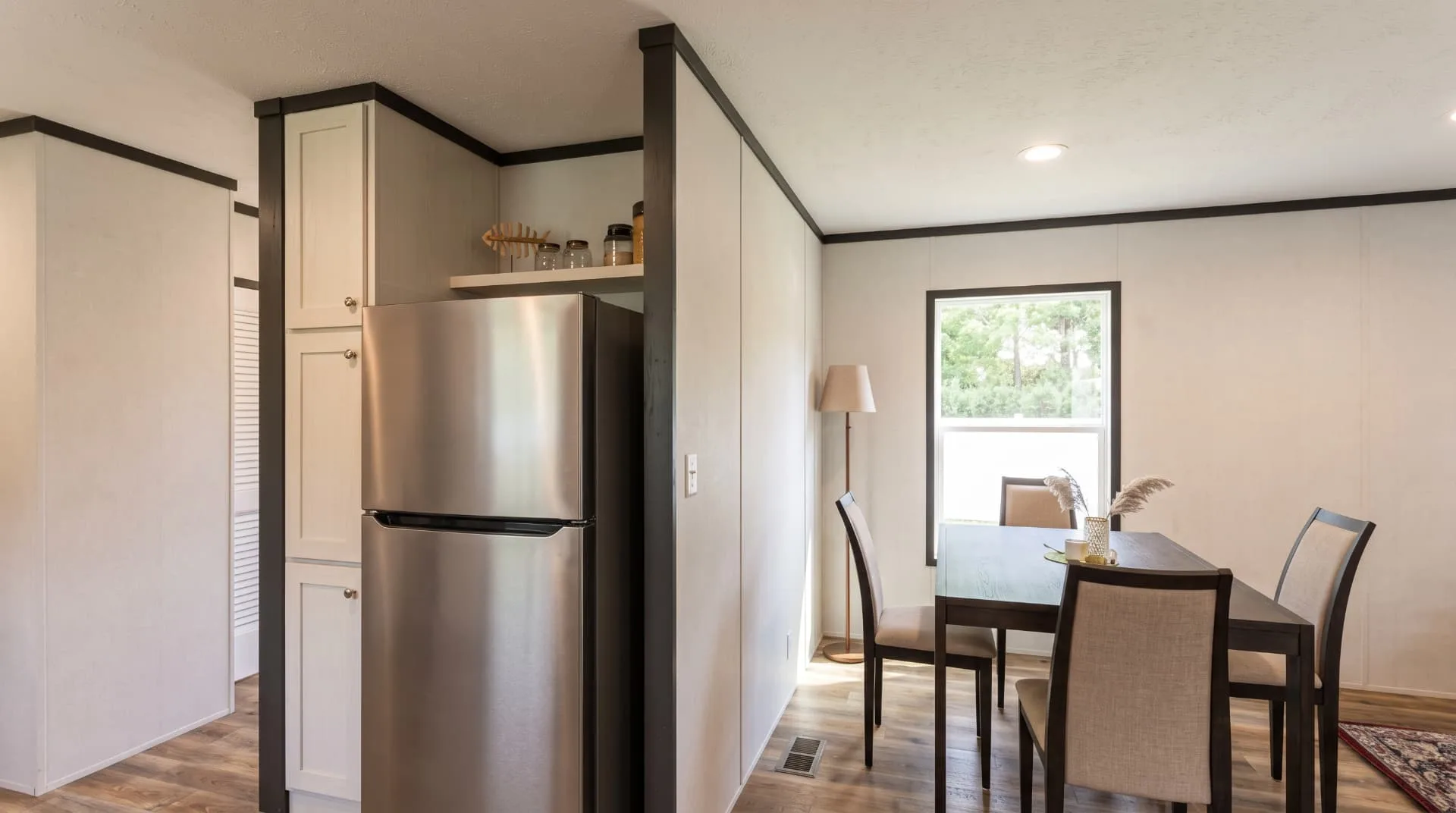 Comedor de la casa móvil Lucía 16x76 con refrigerador y ventana